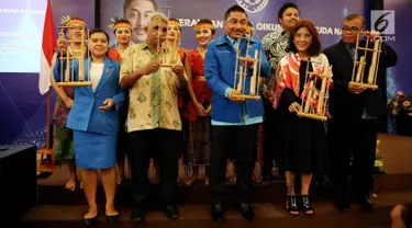 Menteri Kelautan dan Perikanan Susi Pudjiastuti (kedua kiri) dan Politisi Partai Demokrat Michael Wattimena (ketiga kiri) membunyikan angklung tanda membuka acara Rakornas GAMKI, Jakarta, Jumat (12/1). (Liputan6.com/Johan Tallo)