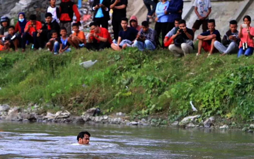 Panji Petualang loncat ke Sungai Palu, Sulawesi Tengah, untuk memastikan ada tidaknya buaya berkalung ban. (Foto: Dite Surendra/Jawa Pos)