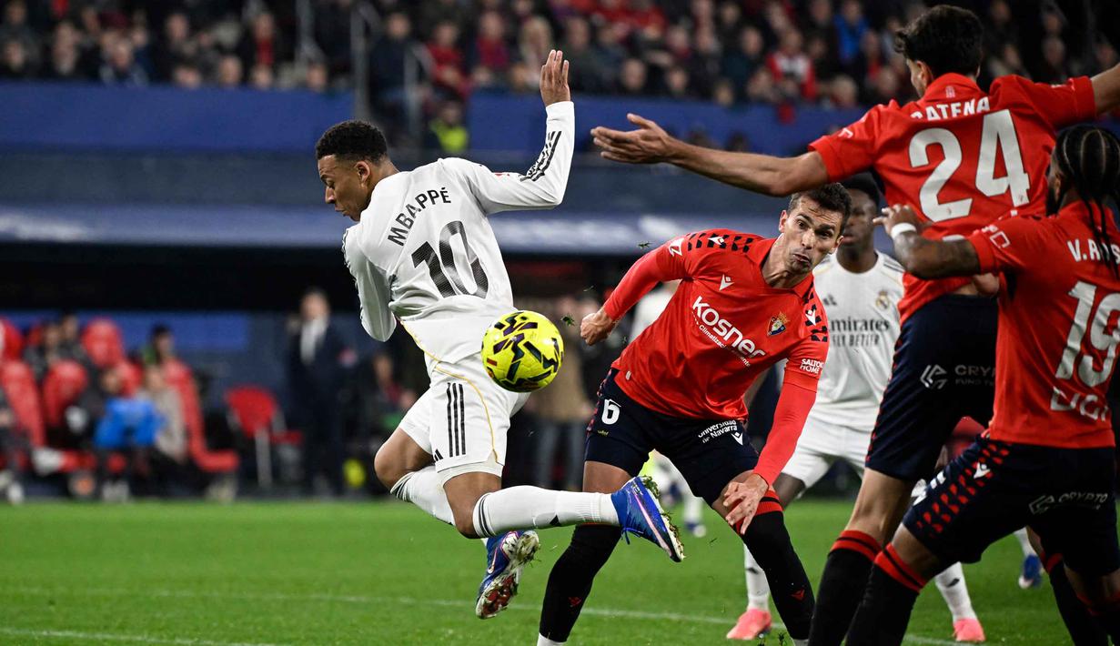 Bertanding di depan publik sendiri, Osasuna langsung menunjukkan keberanian tampil menekan pemuncak klasemen, Real Madrid. Tampak dalam foto, penyerang Real Madrid asal Prancis, Kylian Mbappe (kiri) saat berebut bola dengan gelandang Osasuna asal Spanyol, Lucas Torro Marset selama pertandingan pekan ke-25 La Liga 2025/2026 di Stadion El Sadar, Pamplona pada Sabtu 21 Februari 2026 waktu setempat atau Minggu (22/2/2026) dini hari WIB. (ANDER GILLENEA/AFP)