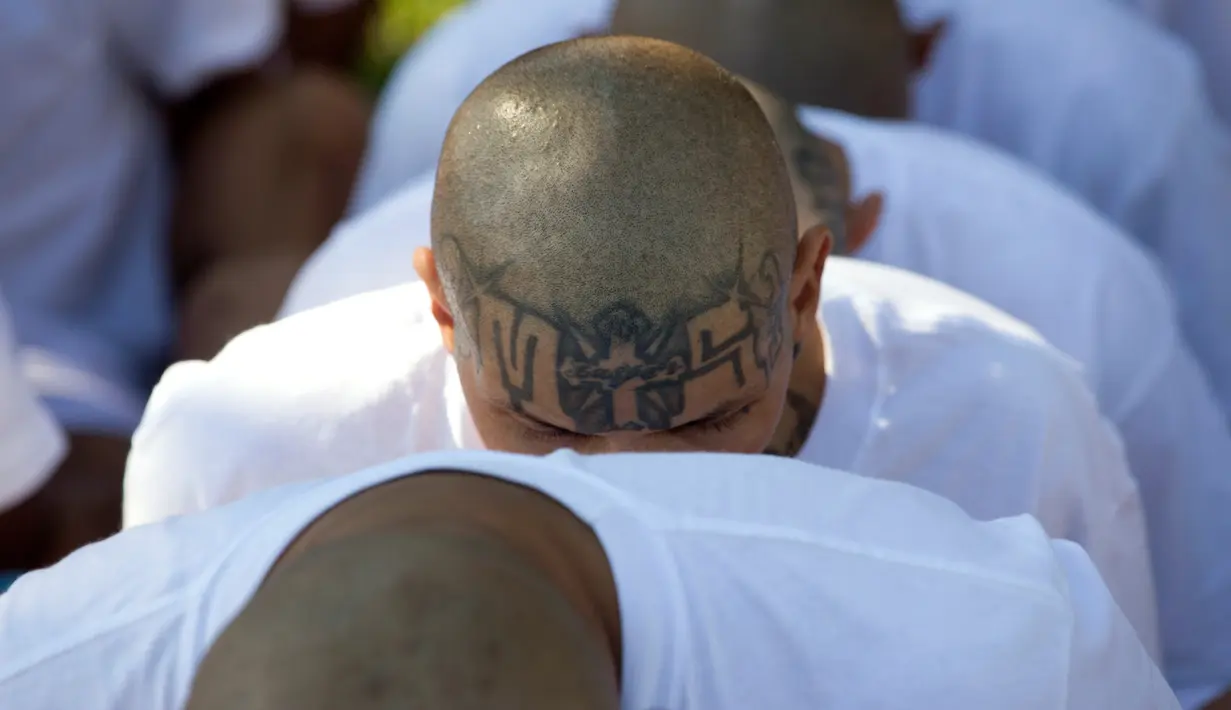 Anggota geng Mara Salvatrucha (MS-13) duduk di penjara dengan keamanan maksimal di Zacatecoluca, El Salvador (31/1). Sebagian besar anggotanya yang terdiri dari orang El Salvador, Honduras, Guatemala. (AP Photo/Moises Castillo)