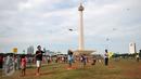 Sejumlah pengunjung bermain layang-layang di kawasan Monas, Jakarta, Sabtu (26/12/2015). Libur Natal dimanfaatkan sejumlah warga untuk berwisata ke tempat yang menjadi ikon Jakarta tersebut. (Liputan6.com/Yoppy Renato)