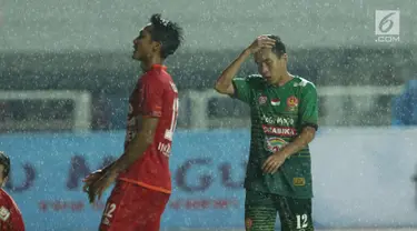 Pemain tengah PS TNI, Erwin Ramdani (kanan) memegang kepala saat gagal mencetak gol ke gawang Arema FC dilanjutan Liga 1 Indonesia di Stadion Pakansari, Bogor, Senin (3/7). Laga kedua tim berakhir imbang 0-0. (Liputan6.com/Helmi Fithriansyah)