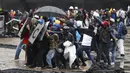 Pengunjuk rasa antipemerintah mengembalikan tabung gas air mata ke polisi saat bentrokan di Bogota, Kolombia, Rabu (5/5//2021). Sebanyak 24 orang (18 di antaranya karena luka tembak) telah tewas dan ratusan lainnya luka-luka akibat bentrokan. (AP Photo/Fernando Vergara)
