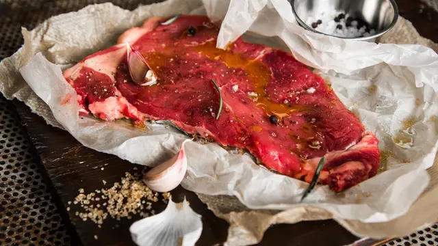 Sepotong daging sapi yang sedang dimarinasi (Foto Dok: Freepik/wirestock)