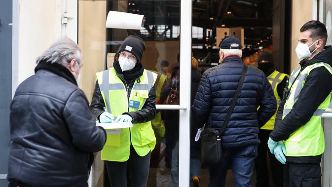 Para staf bekerja di pintu masuk lokasi vaksinasi COVID-19 di Berlin, ibu kota Jerman (27/12/2020).  Jerman sudah memberi suntikan pertamanya sehari lebih awal, hanya beberapa jam setelah menerima kiriman vaksin pertamanya. (Xinhua/Shan Yuqi)