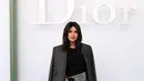Priyanka Chopra tampil sophisticated dalam balutan jaket wol abu-abu yang dipadukan dengan atasan katun hitam serta rok sutra bermotif warna-warni. Ia juga mengenakan aksesori Dior untuk menyempurnakan gayanya.[Image Credit: Getty Images/DIOR]