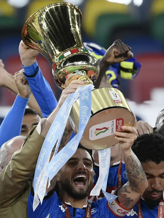 Pemain Napoli Lorenzo Insigne memegang trofi setelah timnya mengalahkan Juventus pada final Coppa Italia di Olympic Stadium, Roma, Italia, Rabu (17/6/2020). Napoli menjadi juara Coppa Italia 2019-2020 setelah mengalahkan Juventus lewat drama adu penalti. (Filippo MONTEFORTE/AFP)