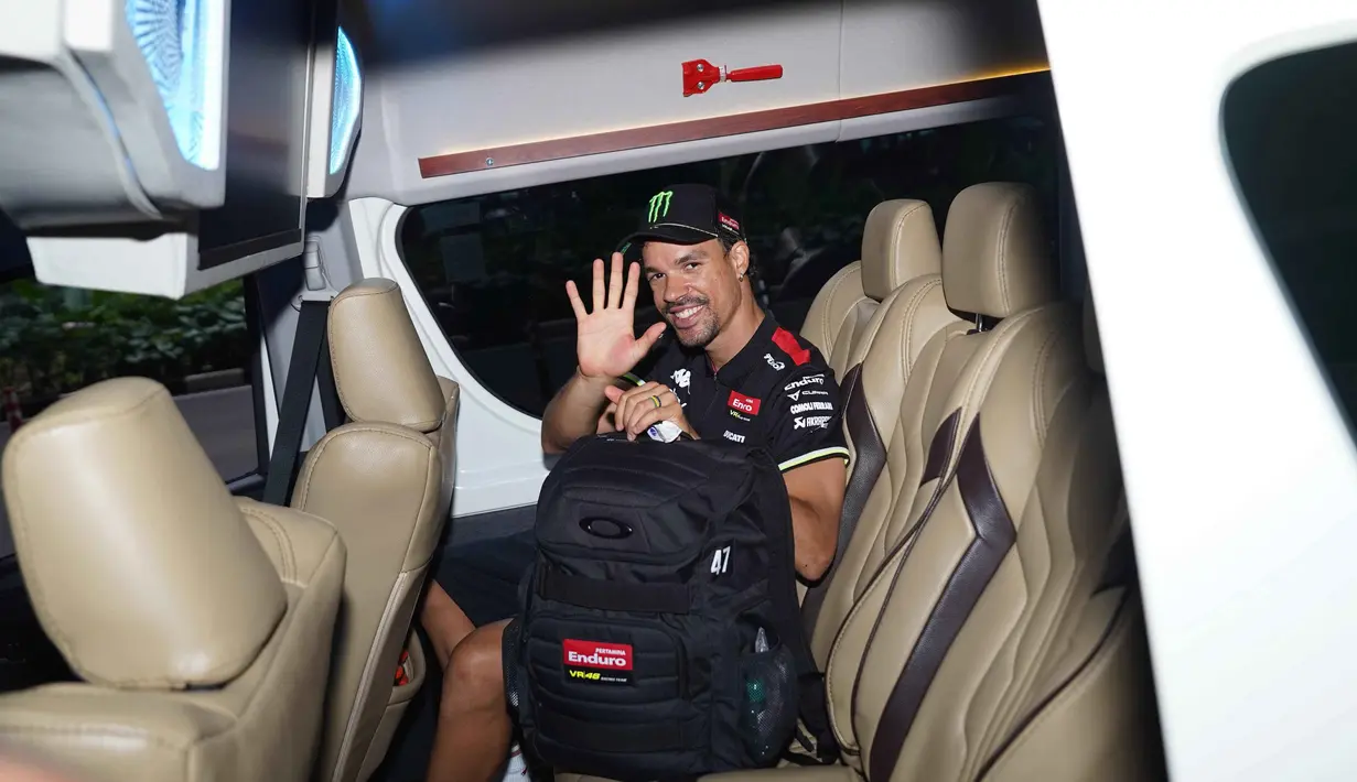 Kegiatan ini merupakan upaya dari tim Pertamina Enduro VR46 Racing Team untuk mengapresiasi dukungan fans Indonesia. Tampak dalam foto, Franco Morbidelli melambaikan tangan dari dalam kendaraan yang membawanya menuju hotel sesaat setelah tiba di Bandara Soekarno-Hatta, Tangerang, Banten pada Senin (29/9/2025) malam. (Foto: Istimewa)