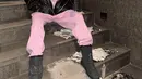 Padu padan menarik dari Lisa BLACKPINK pakai hoodie pink yang serasi dengan sweat pantsnya. Ia tumpuk dengan jaket kulit hitam, dan high boots yang juga berwarna hitam. [Foto: Instagram/lalalalisa_m]