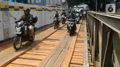 Pengendara motor melintas di jembatan darurat atau bailey Cikereteg di Jalan Raya Bogor-Sukabumi, Bogor, Jawa Barat, Senin (13/3/2023). Mulai Senin, (13/3/2023) jalur tersebut kembali dibuka hanya untuk kendaraan kecil dengan sistem buka tutup. (merdeka.com/Arie Basuki)