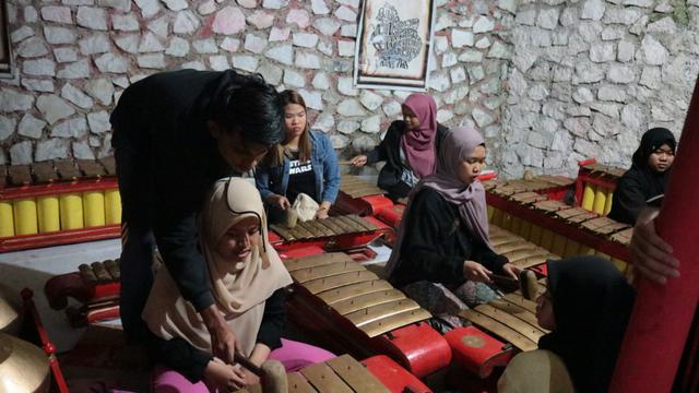 Mahasiswa asing belajar gamelan dalam ISC 2019 di UMP, Purwokerto. (Foto: Liputan6.com/UMP/Muhamad Ridlo)