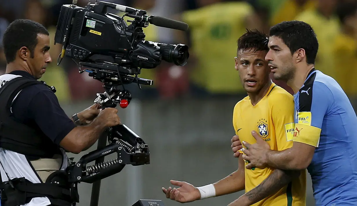 Penyerang Uruguay, Luis Suarez (kanan) saat mencoba mengontrol kemarahan rekan setimnya di Barcelona, Neymar, Stadion Arena Pernambuco, Brasil, (25/3). Pertandingan ini akhirnya berkesudahan dengan skor 2-2. (REUTERS / Paulo Whitaker)