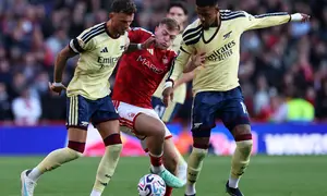 Bek Arsenal Ben White (kiri) dan Ezri Konsa (kanan) mengepung striker Nottingham Forest Liam Delap pada laga Liga Inggris 2026/2027 di City Ground. (AFP/Darren Staples)