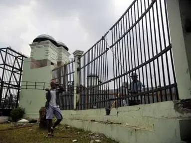 Dua orang pekerja memperbaiki pagar gedung DPR/MPR di Jakarta, Senin (2/4). DPR mengalokasikan dana sebesar Rp 200 juta untuk memperbaiki pagar DPR yang rusak akibat dijebol pengunjuk rasa yang menolak harga kenaikan BBM. (Antara)