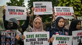 Para aktivis menggelar unjuk rasa menentang pencegatan kapal-kapal yang berpartisipasi dalam armada Global Sumud Flotilla (GSF), sebuah misi bantuan kemanusiaan ke Gaza melalui jalur laut, di Surabaya, Jawa Timur pada Kamis 21 Mei 2026. (JUNI KRISWANTO/AFP)