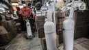 Pedagang membawa tabung oksigen ukuran 1 kubik yang sudah dipesan pembeli di Pasar Pramuka, Jakarta, Kamis (24/6/2021). Kelangkaan tabung oksigen  akibat meningkatnya permintaan seiring lonjakan kasus Covid-19 di Ibu Kota. (merdeka.com/Iqbal S. Nugroho)