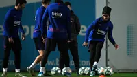 Penyerang Barcelona, Antoine Griezmann (kanan) mengumpan bola saat mengikuti sesi latihan tim di Joan Gamper Sports City di Sant Joan Despi (17/12/2019). Barcelona akan bertanding melawan Real Madrid dalam laga El Clasico di Camp Nou. (AFP/Lluis Gene)