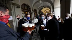 Orang-orang mengantre untuk minum bir di teras restoran di Praha, Republik Ceko, Senin, (11/5/2020). Republik Ceko mengambil langkah normal di tengah pandemi coronavirus dengan melonggarkan lebih banyak pembatasan yang diadopsi oleh pemerintah untuk menampungnya. (AP/Petr David Josek)