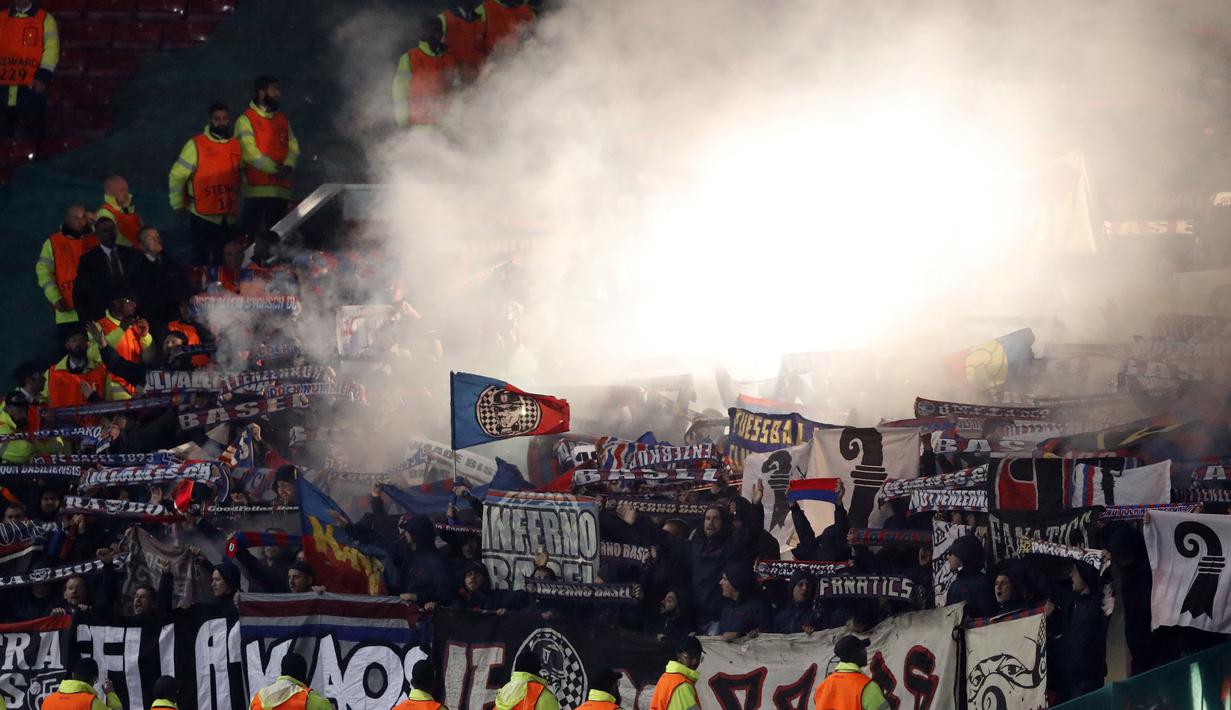 Fans Basel menyalakan flares saat mendukung timnya melawan Manchester United pada laga  grup A Liga Champions di Old Trafford, Manchester, (12/9/2017). MU menang 3-0. (AP/Frank Augstein)