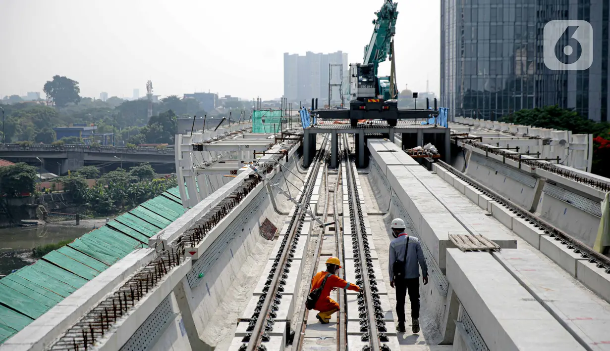 Pekerja mengecek perlintasan LRT di jembatan bentang panjang Dukuh Atas, Jakarta, Rabu (11/11/2020). Jembatan bentang panjang hari ini melakukan pengecoran terakhir panjangnya 128 meter. pekerjaan ini menandai selesainya pengerjaan lintasan atas LRT Jabodebek tahap I. (Liputan6.com/Faizal Fanani)