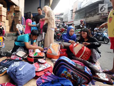 Warga memilih tas yang dijajakan pedagang kaki lima di sekitar Pasar Asemka, Jakarta, Rabu (5/7). Jelang bergantinya tahun ajaran baru, sejumlah warga berburu peralatan sekolah di kawasan Pasar Asemka Jakarta. (Liputan6.com/Helmi Fithriansyah)