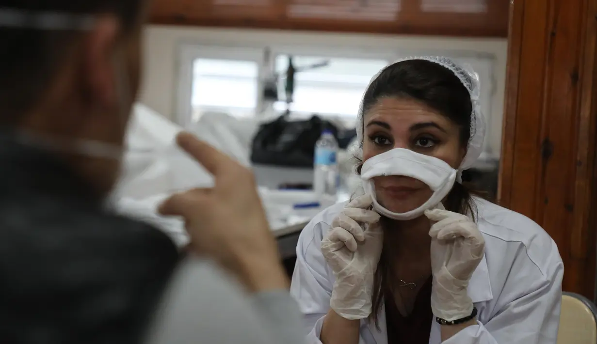 Seorang pekerja menunjukkan masker transparan di Istanbul, Turki, Rabu (27/5/2020). Produksi masker wajah ini dirancang khusus bagi kaum tunarungu setelah mengamati masker biasa sangat membatasi komunikasi karena menyulitkan mereka untuk membaca gerak bibir. (Xinhua/Osman Orsal)