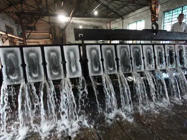 Seorang pekerja membuat es balok di sebuah pabrik di Yangzhou di provinsi Jiangsu timur China (8/7). (AFP Photo/China Out)