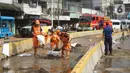 Petugas Penanganan Prasaran dan Sarana Umum (PPSU) membersihkan lumpur yang mengendap di sepanjang Jalan Jatinegara Barat, Kampung Melayu, Jakarta Timur, Kamis (2/1/2020). Petugas melakukan bersih-bersih menyusul mulai surutnya banjir di kawasan tersebut. (Liputan6.com/Immanuel Antonius)
