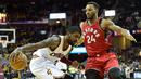 Pemain Cleveland Cavaliers, Kyrie Irving (kiri), berusaha melewati pemain Toronto Raptors, Norman Powell, pada laga pramusim NBA di Quicken Loans Arena, Jumat (14/10/2016). (Reuters/David Richard-USA TODAY Sports)