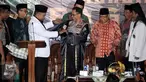 Sekjen Pagar Nusa M Nabil Haroen memberikan jubah kehormatan pencak silat Nahdlatul Ulama (PSNU) Pagar Nusa kepada Kapolri Jendral Tito Karnavian pada acara pembukaan Kongres III PSNU di TMII, Jakarta, Rabu (3/5). (Liputan6.com/Johan Tallo)