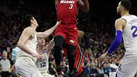 Pemain Miami Heat, Dwyane Wade melakukan tembakan melewati adangan para pemain Philadelphia 76ers pada NBA basketball playoff series di Wells Fargo Center, Philadelphia, (16/4/2018). Heat menang 113-103. (AP/Chris Szagola)