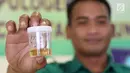 Sopir bus Antar Kota Antar Provinsi (AKAP) memperlihatkan sampel urine saat tes kesehatan di Terminal Pulo Gebang, Jakarta, Kamis (22/6). Tes urine untuk memastikan sopir dalam kondisi sehat dan tidak mengonsumsi narkoba (Liputan6.com/Immanuel Antonius)