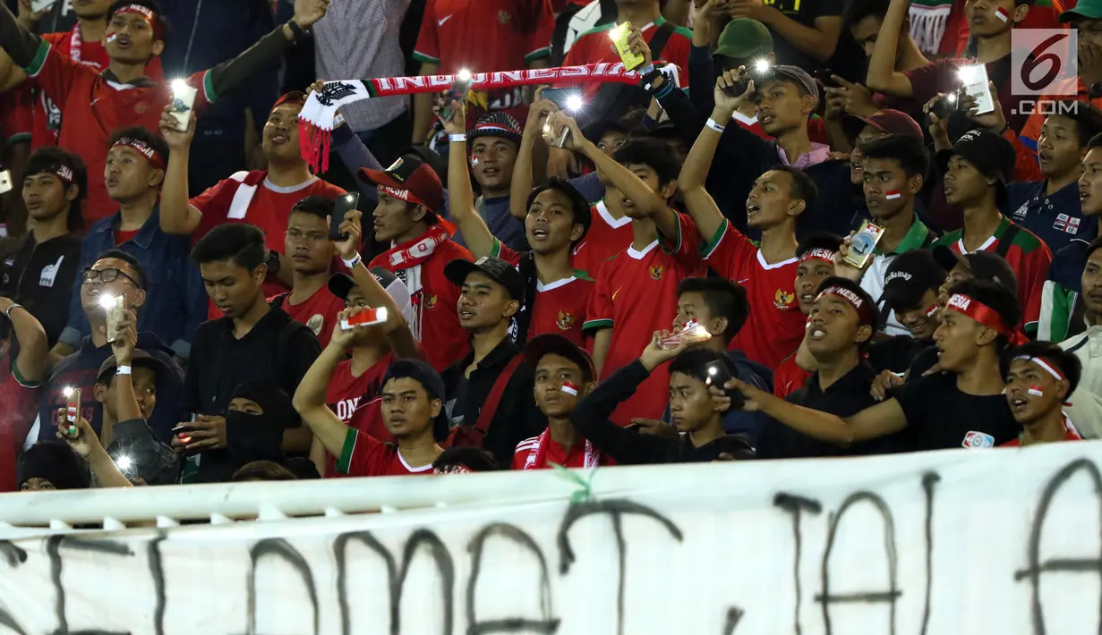 Suporter menyaksikan laga Indonesia U-19 melawan China U-19 pada PSSI 88th U-19 International Tournament di Stadion Pakansari, Selasa (25/9). Suporter membentangkan spanduk keprihatinan atas aksi kekerasan yang terjadi. (Liputan6.com/Helmi Fithriansyah)