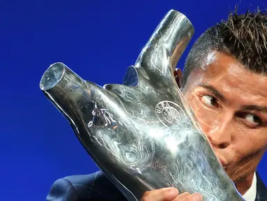 Penyerang Real Madrid, Cristiano Ronaldo mencium trofi setelah terpilih sebagai Pemain Terbaik Eropa musim 2015-2016 usai drawing penyisihan grup Liga Champions di Monako, (25/8). (REUTERS/Eric Gaillard)
