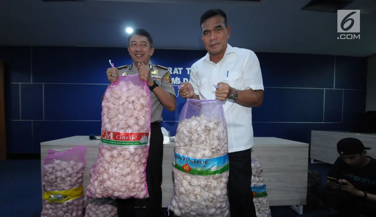 Wadir Tipideksus Bareskrim Polri, Kombes Pol Daniel Tahi Monang Silitonga (kanan) menunjukan barang bukti penyalahgunaan distribusi bawang putih impor di Jakarta, Kamis (31/5). DirTipideksus berhasil menahan 30.000 ton. (Liputan6.com/Helmi Fithriansyah)