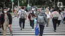 Pekerja kantoran melintas di pelican cross kawasan Jalan Thamrin, Jakarta, Kamis (5/1/2023). Pencabutan Pemberlakuan Pembatasan Kegiatan Masyarakat (PPKM) dinilai untuk menggenjot ekonomi Indonesia 2023 yang diproyeksi suram akibat resesi global. (Liputan6.com/Faizal Fanani)