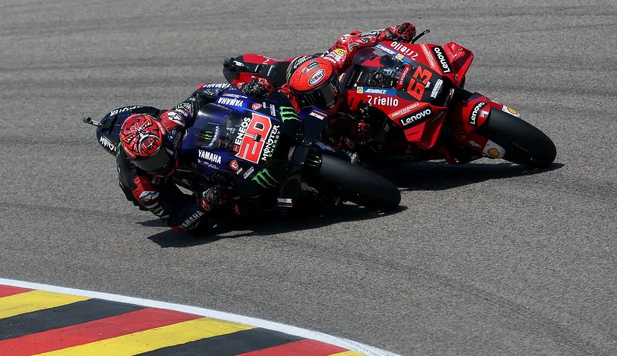 Fabio Quartararo (kiri) yang memulai balapan di MotoGP Jerman 2022 dari posisi kedua langsung merebut posisi terdepan dari Francesco Bagnaia di lap pertama pada tikungan pertama. (AFP/Ronny Hartmann)