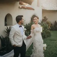 Aaliyah Massaid tampil memesona dalam balutan off-the-shoulder dress berwarna putih. Dress pilihan Aaliyah Massaid untuk momen pre-weddingnya dengan Thariq Halilintar ini memiliki detail bulu pada keseluruhan dressnya, dan train panjang menjuntai dari bagian punggung, serta gloves putih yang mempermanis penampilannya. [Foto: Instagram/thariqhalilintar]