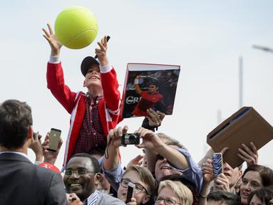 Seorang penggemar cilik menangkap bolanya kembali setelah ditanda tangani petenis Swiss, Roger Federer di Biel, Swiss, (21/4/2016). (AFP/Fabrice Coffrini)