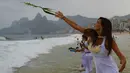 Masyarakat Brasil percaya dengan melakukan ritual Lemanja akan membawa kedamaian dan kebahagiaan pada hari-hari mereka, Pantai Arpoador, Rio de Janeiro, Brasil, Senin (2/2/2015). (AFP Photo/Yasuyoshi Chiba)