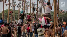 Warga mengikuti lomba Panjat Pinang Kolosal dalam rangka merayakan HUT ke-74 Kemerdekaan RI di Pantai Karnaval Ancol, Jakarta, Senin (17/8/2019). Sebanyak 174 batang pinang dengan beragam hadiah disediakan dalam lomba yang diikuti ratusan warga itu. (Liputan6.com/Faizal Fanani)
