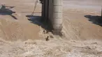 Dua nelayan terjatuh di tengah banjir setelah tali putus saat operasi penyelamatan gagal menggunakan helikopter Angkatan Udara India di Sungai Tawi di Jammu, India (19/8/2019). Kedua nelayan tersebut selamat kemudian berenang ke tempat yang aman. (AP Photo/Channi Anand)