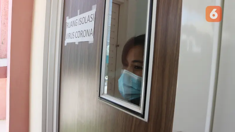 Seorang perawat mengintip dari jendela ruang isolasi yang disiapkan RSUD Undata Palu untuk pasien virus corona. Foto: Heri Susanto.