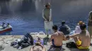 Wisatawan menikmati hari mereka di Danau Band e-Amir, Provinsi Bamiyan, 4 Oktober 2021. Danau Band-e Amir yang memiliki perairan biru menakjubkan disebut juga sebagai Grand Canyon Afghanistan. (BULENT KILIC/AFP)
