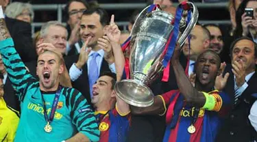 Bek Barcelona asal Prancis Eric Abidal (kanan) mengangkat trofi Liga Champions usai mengalahkan Manchester United dalam partai final di Wembley Stadium, 28 Mei 2011. AFP PHOTO/CARL DE SOUZA