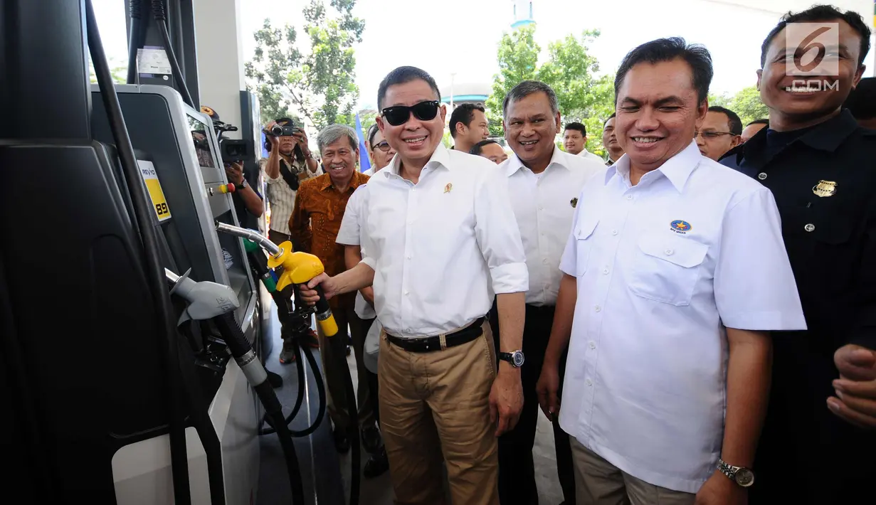 Menteri ESDM, Ignasius Jonan (tengah) mencoba selang pengisian BBM saat meninjau SPBU Vivo di kawasan Cilangkap, Jakarta, Kamis (26/10). SPBU tersebut akan menyalurkan BBM bensin RON 89, 90, dan 92 dengan merk Revvo. (Liputan6.com/Helmi Fithriansyah)