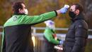Petugas memeriksa suhu tubuh suporter West Ham United sebelum menyaksikan pertandingan melawan Manchester United di Stadion London, Sabtu (5/12/2020). (Justin Setterfield/Pool Via AP)