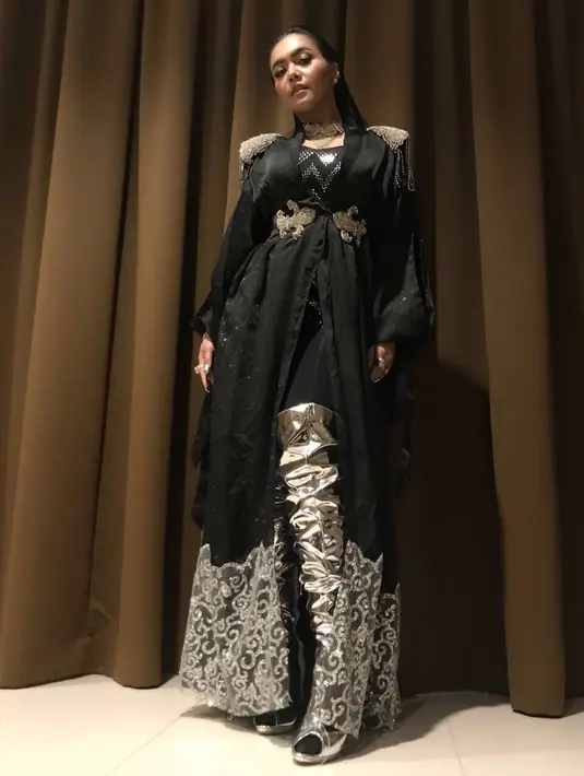 Selain nyentri, Denada pun juga sering banget bergaya glamor seperti ini setiap penampilannya di atas panggung. Gaun hitam yang menjuntai menjadi pilihannya saat ini. (Instagram/denadaIndonesia)