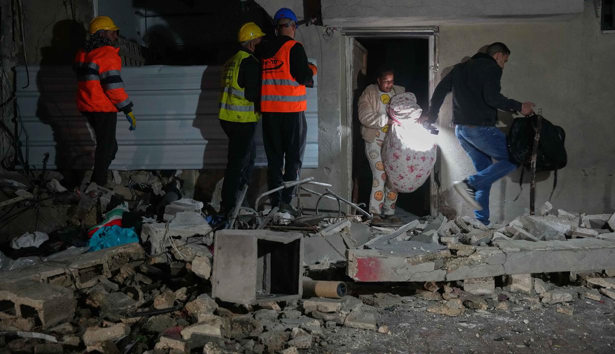 Serangan Israel dan Amerika Serikat tersebut menyebabkan kerusakan signifikan di beberapa wilayah Iran, termasuk gugurnya Pemimpin Tertinggi Iran Ayatollah Ali Khamenei dan pejabat militer lainnya. Tampak dalam foto, warga membawa barang-barang pribadi mereka saat meninggalkan gedung yang rusak akibat serangan rudal Iran di Tel Aviv, Israel, Sabtu 28 Maret 2026 pagi waktu setempat. (AP Photo/Maya Levin)