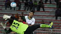 Kiper ATM FA berusaha menghadang sundulan pemain T-Team Malaysia pada laga play-off Malaysia Super League 2016. (Bola.com/Nicklas Hanoatubun)